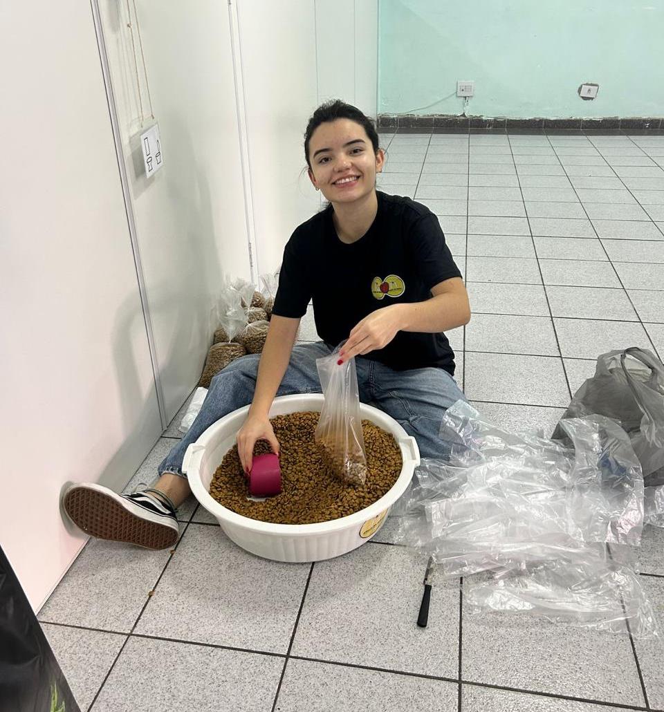 Voluntária separando ração em saquinhos durante a preparação